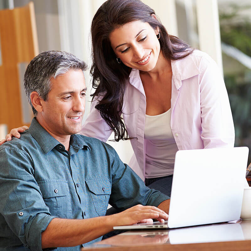 Smiling man and woman looking at laptop computer