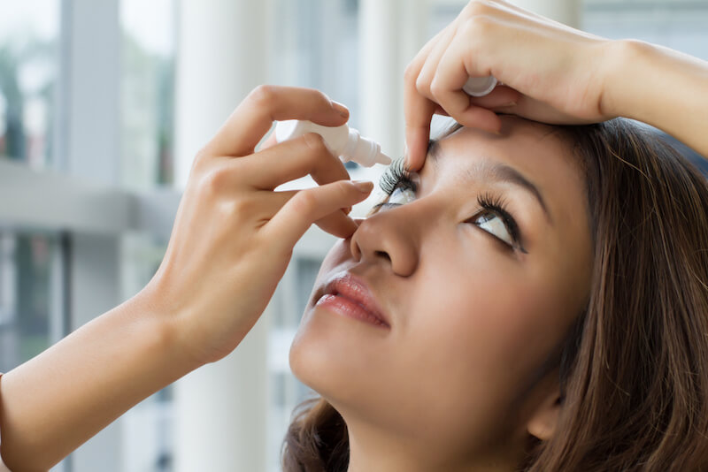 Woman using eye drops to treat dry eye